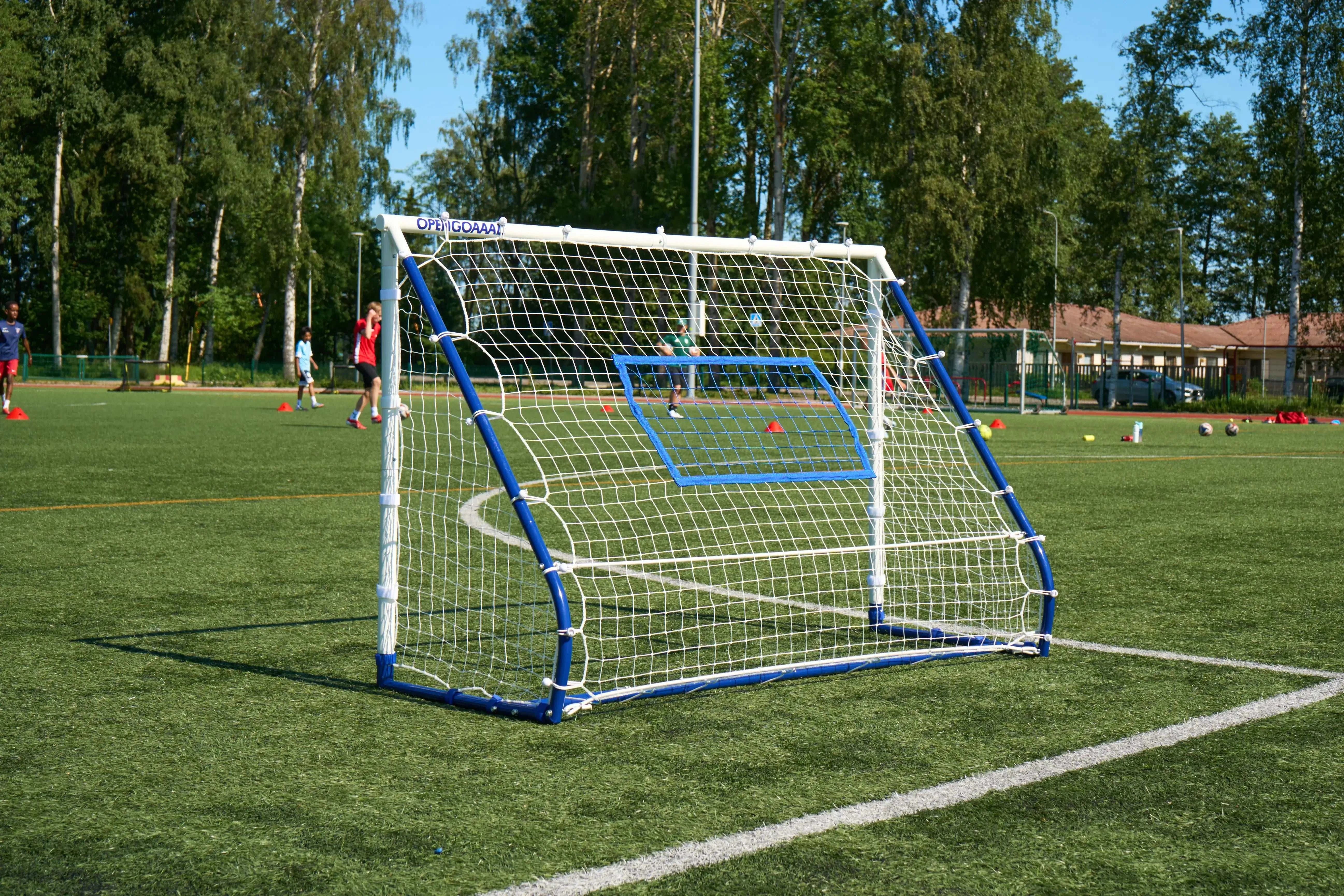 3-in-1 football rebounder goal trainer in a sunny soccer field, perfect for skill-building drills.