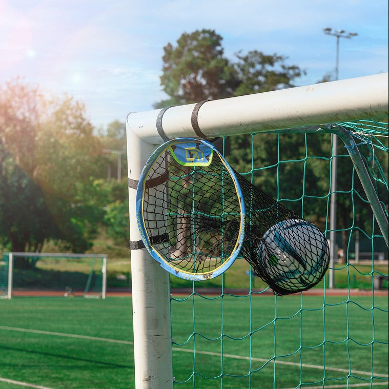 Soccer goal on a grass field with trees and blue sky in the background