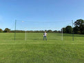 Open Goaaal Regulation size football goal with rebounder and backstop netting on a full-size pitch